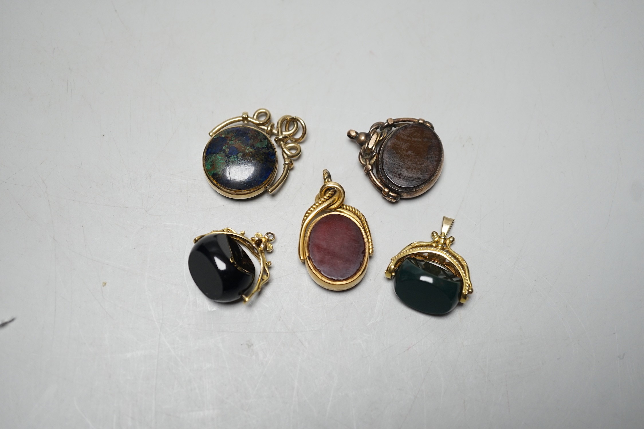 A late Victorian 18ct gold mounted bloodstone and carnelian set spinning fob seal, 36mm, a similar 9ct seal, a yellow metal and turquoise set fob seal and two later 9ct gold mounted seals.
